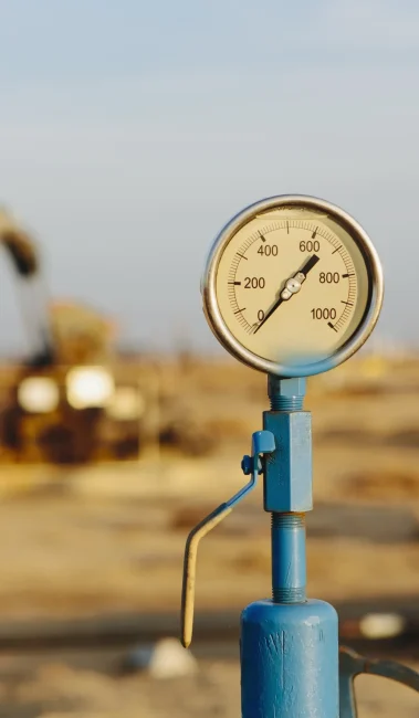 air-pressure-gauge-oil-rigs-in-background-sunset-2025-04-05-05-40-55-utc-min